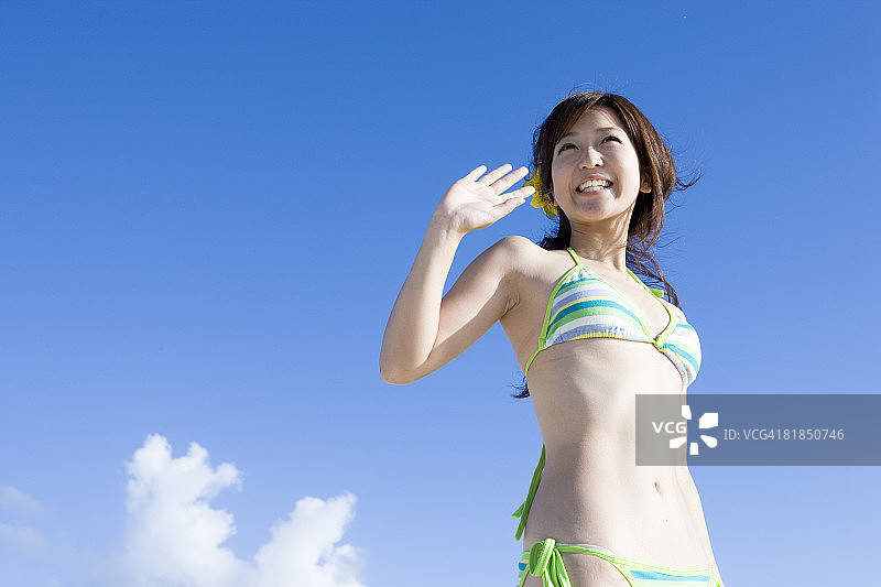 身穿比基尼挥手的年轻女子图片素材