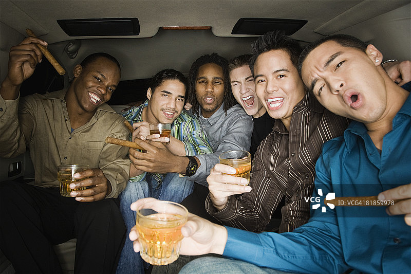 不同种族的男人在豪华轿车里庆祝图片素材