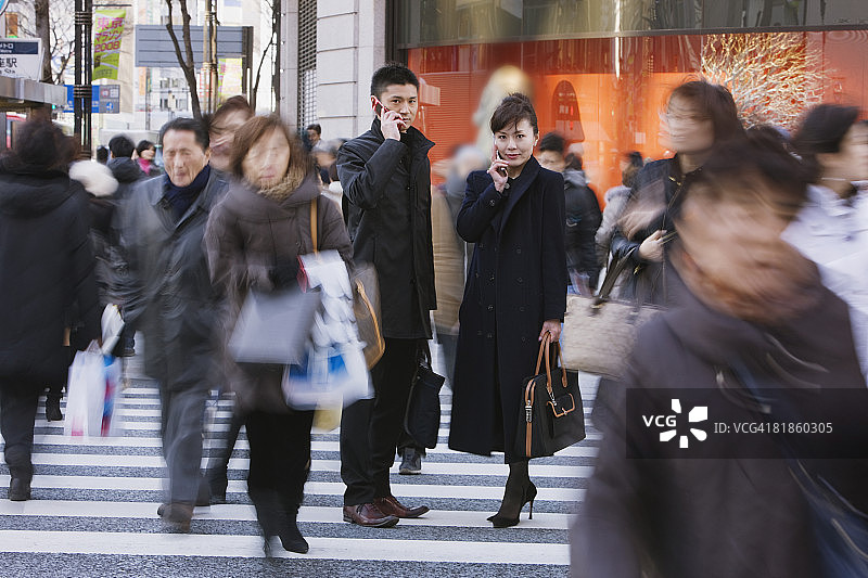 正在用手机交谈的亚洲商务人士图片素材