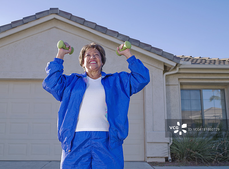 年长的西班牙裔女人用哑铃锻炼图片素材
