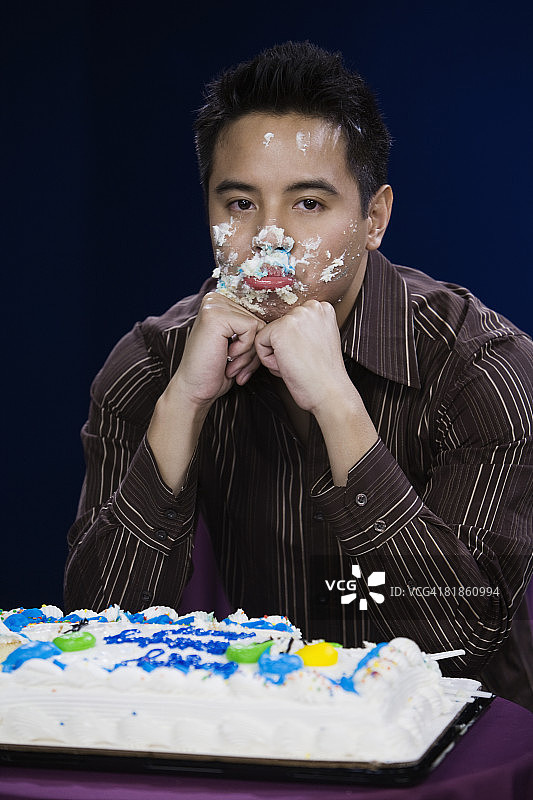 脸上沾着生日蛋糕的亚洲男人图片素材