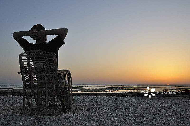 男子坐在椅子上观看红海日出，埃及图片素材