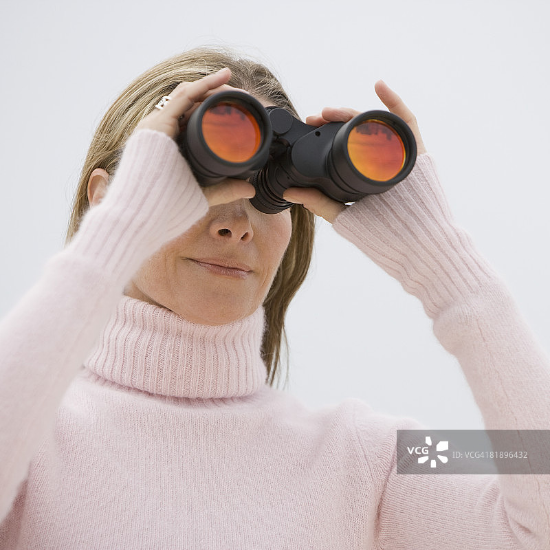 女人用双筒望远镜观看图片素材
