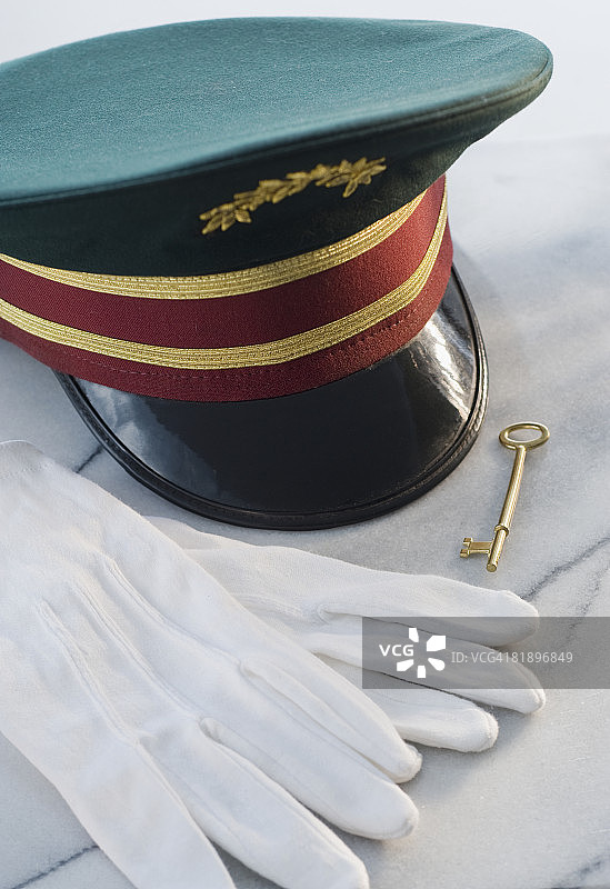 桌子上的门童帽子、手套和钥匙图片素材