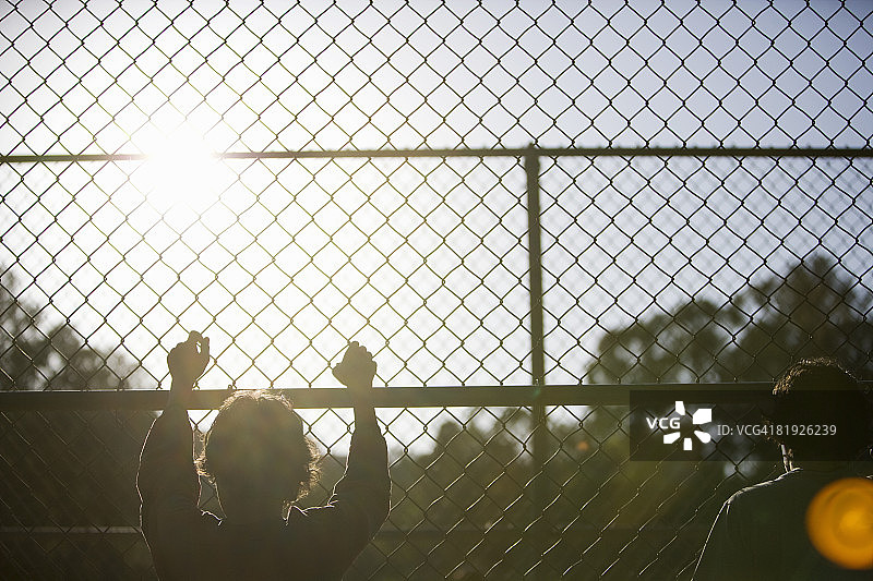 铁丝网围栏旁的两个小男孩图片素材
