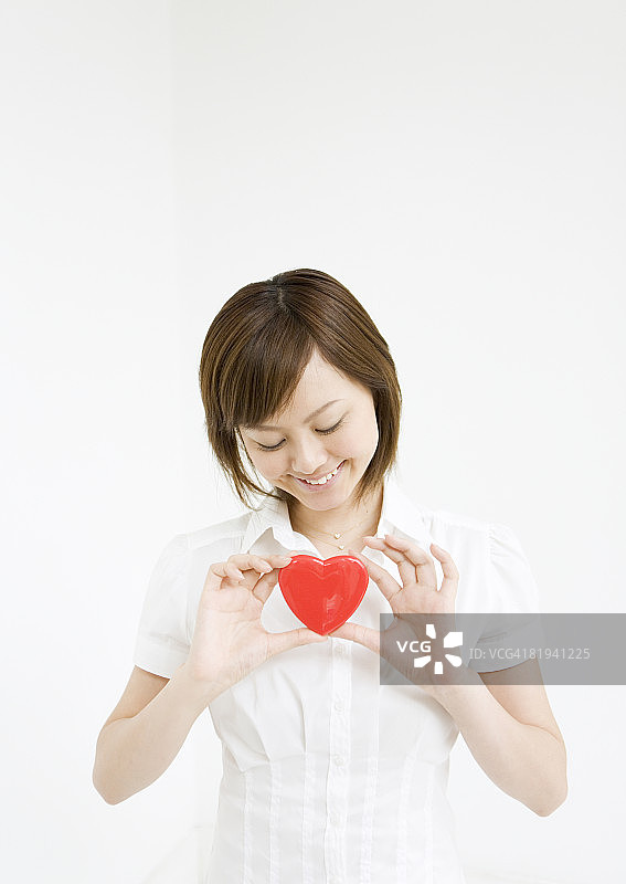 手持心形物体的微笑女人图片素材