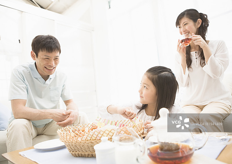 女孩和父母一起吃零食图片素材