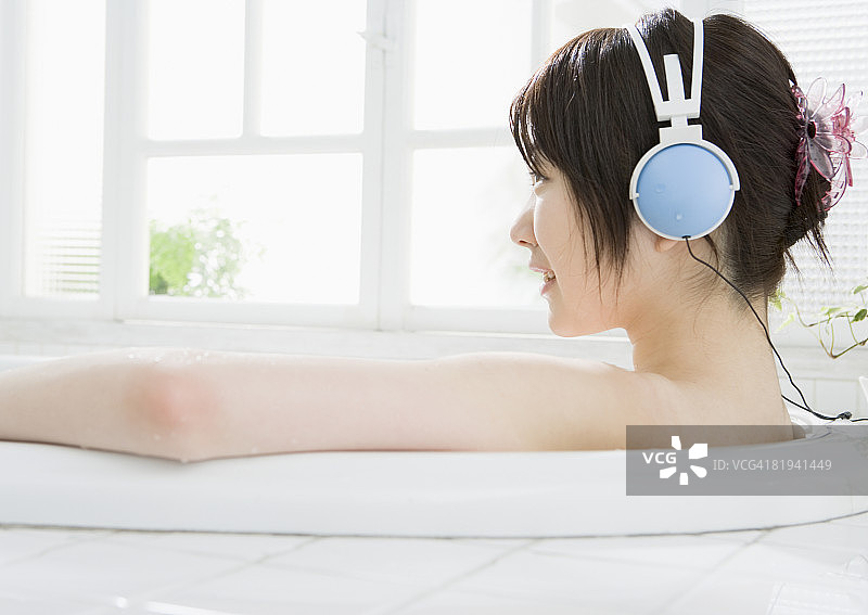 女人在浴缸里听音乐图片素材