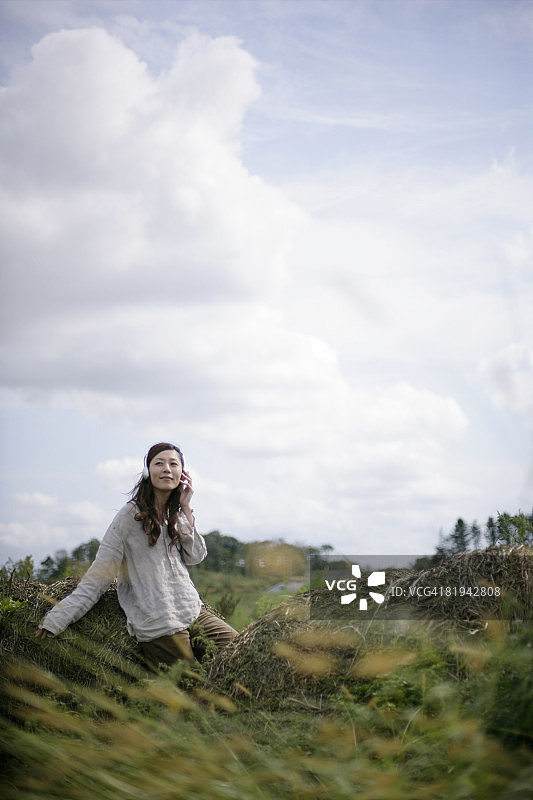 女人在草地上听音乐图片素材