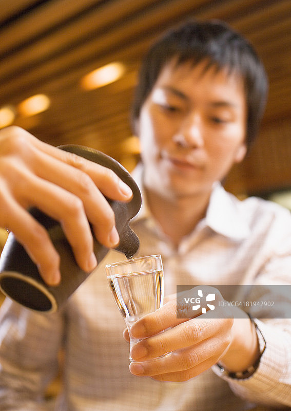 男人倒日本清酒图片素材