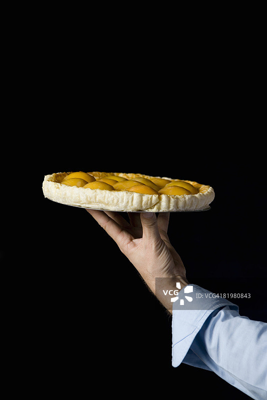 一只手拿着桃子挞，照相馆拍摄图片素材