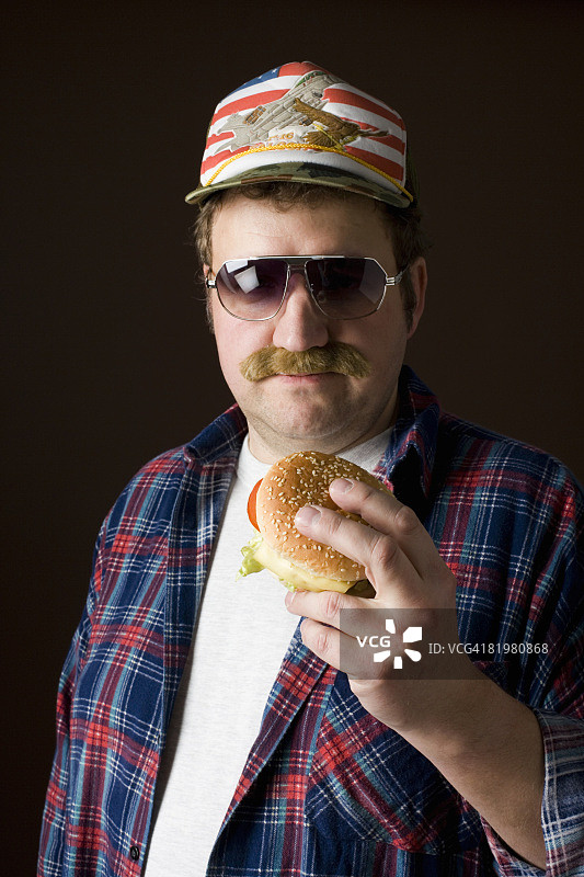 典型的美国男人拿着汉堡包图片素材