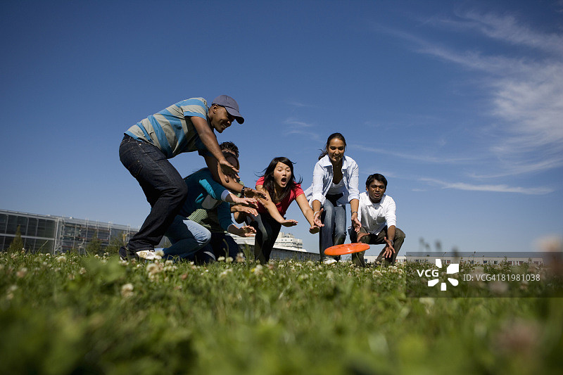 大学生在校园里玩飞盘图片素材
