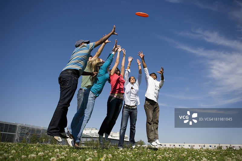 大学生在校园里玩飞盘图片素材