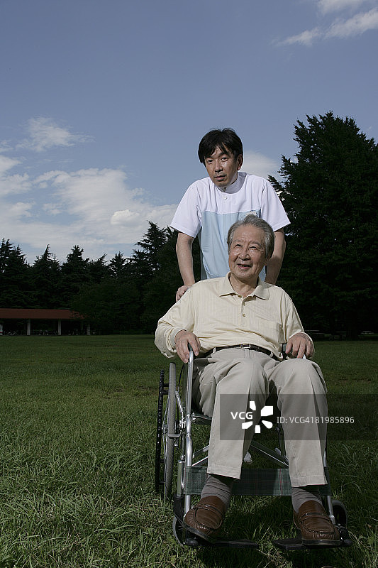 坐在轮椅上的年长男人与男护士的肖像图片素材