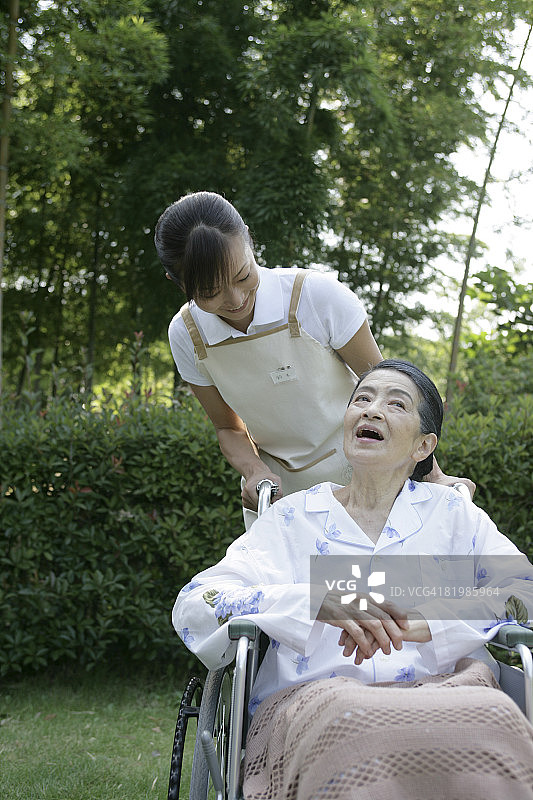 在花园里放松的坐轮椅的中年妇女图片素材