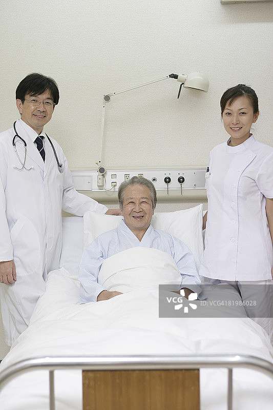 医生和护士站在年长的病人旁边图片素材