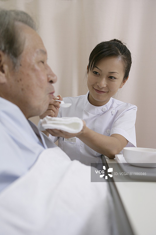 女护士喂年长的病人图片素材