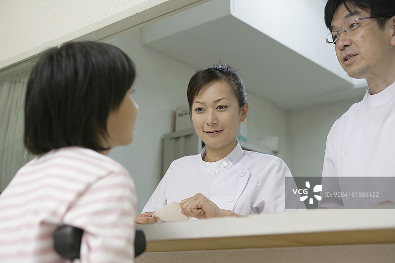 拄着拐杖的女孩与护士交谈图片素材