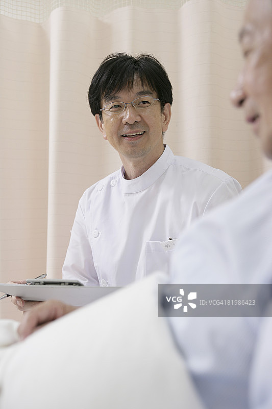 拿着剪贴板与成熟男人聊天的男护士图片素材