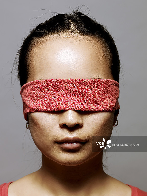 蒙着眼睛的年轻亚洲女人图片素材