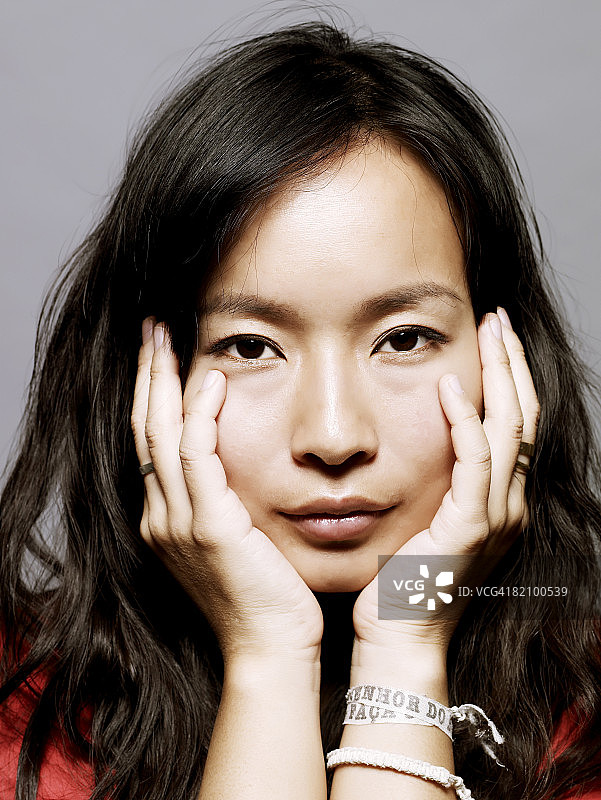 用手捂住脸的亚洲年轻女人图片素材