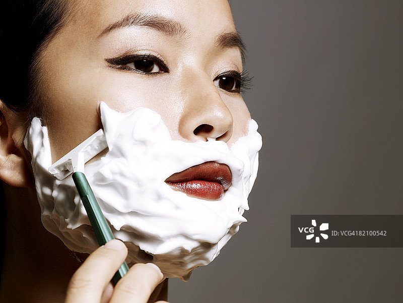 正在剃须的年轻亚洲女性图片素材