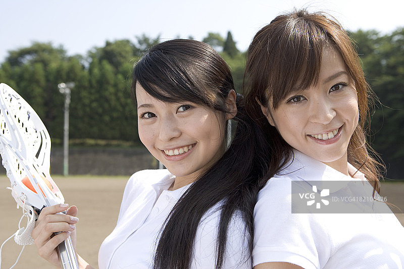 两名年轻女子手持曲棍球棒图片素材