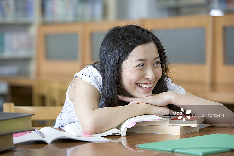坐在图书馆里微笑的女学生图片素材