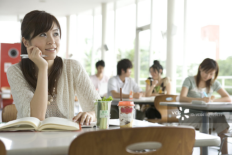 学习中的女学生，背景中有其他四个学生图片素材