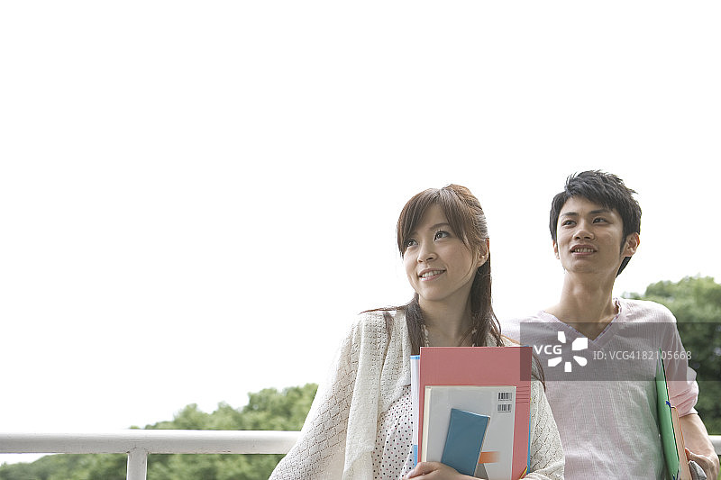 学生情侣户外放松低角度拍摄图片素材