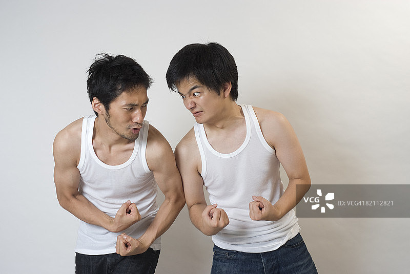 两个年轻男人互相展示肌肉图片素材