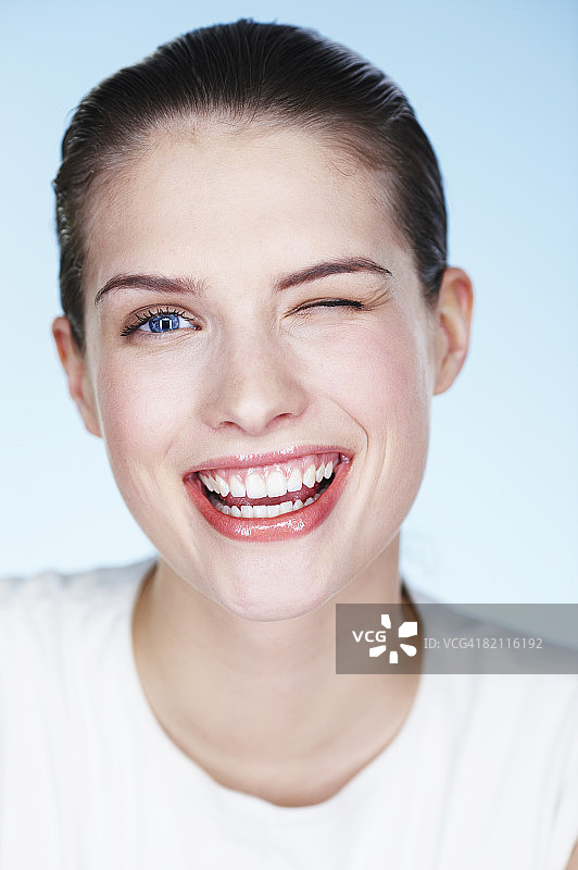 年轻微笑女子眨眼肖像图片素材