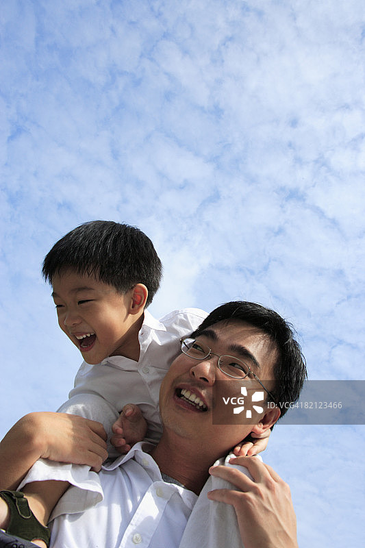 仰视扛着儿子的中年男人图片素材