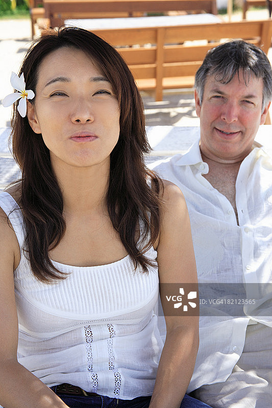 中年妇女与年长男人坐在一起，假笑的特写图片素材