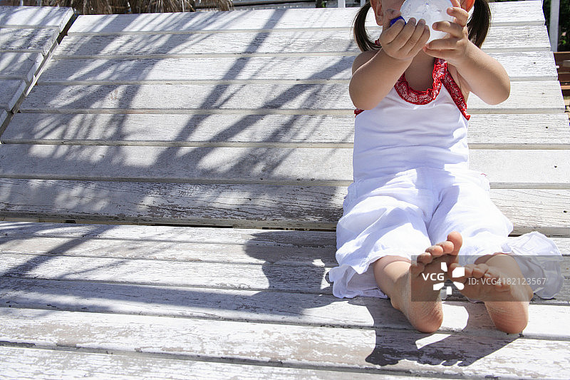 女孩坐在躺椅上喝水图片素材