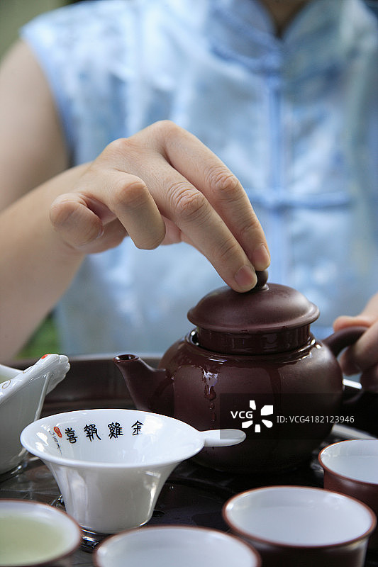 中年妇女准备茶的腰部视角图片素材