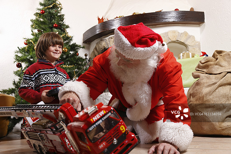 圣诞老人和玩玩具的小男孩图片素材