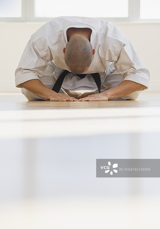 系着空手道黑带的西班牙裔男人在鞠躬图片素材