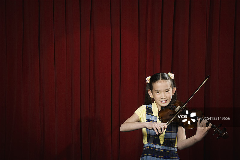 在舞台上拉小提琴的亚洲女孩图片素材