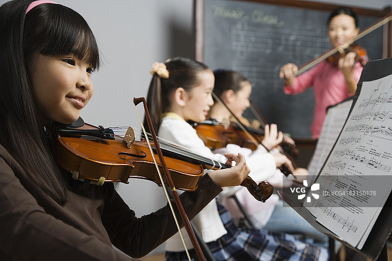 在音乐课上拉小提琴的亚洲女孩图片素材