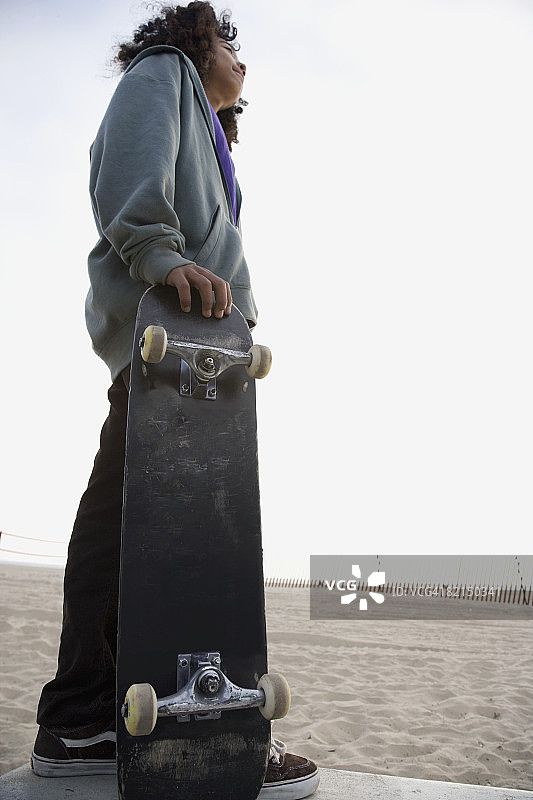 手持滑板的混血男孩图片素材