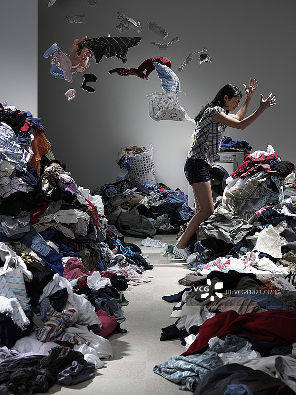 女人在满溢的洗衣房里扔衣服图片素材