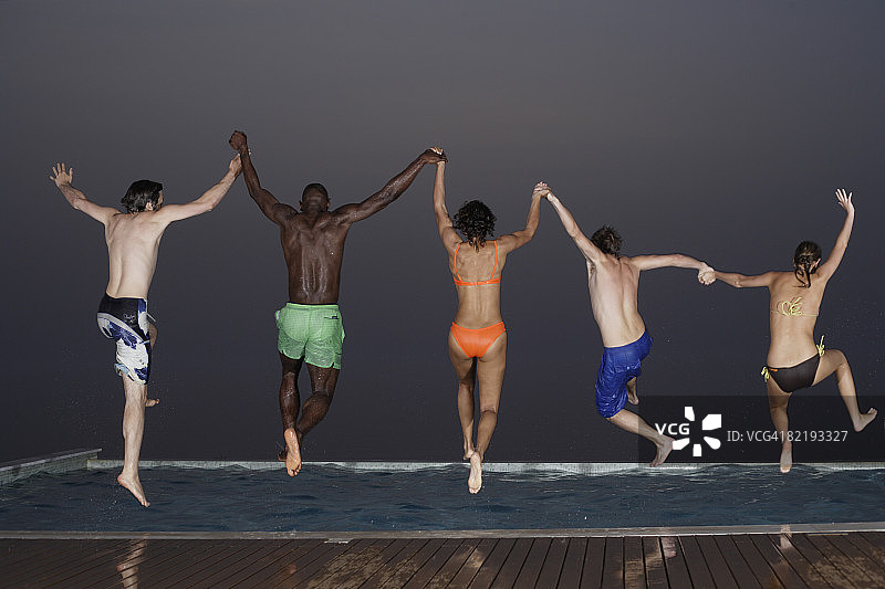 五个成年人在夜晚跳入泳池图片素材