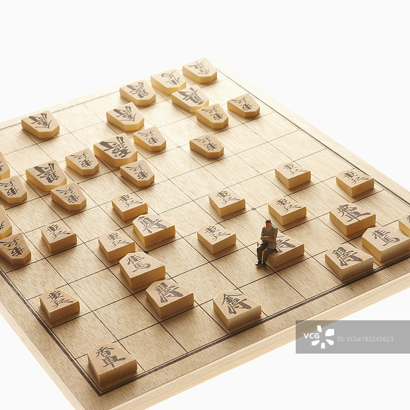 男子坐在棋子的国王上图片素材