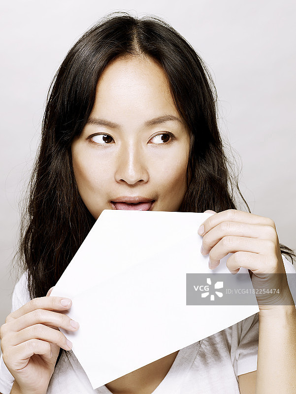 舔信封的年轻亚洲女子图片素材