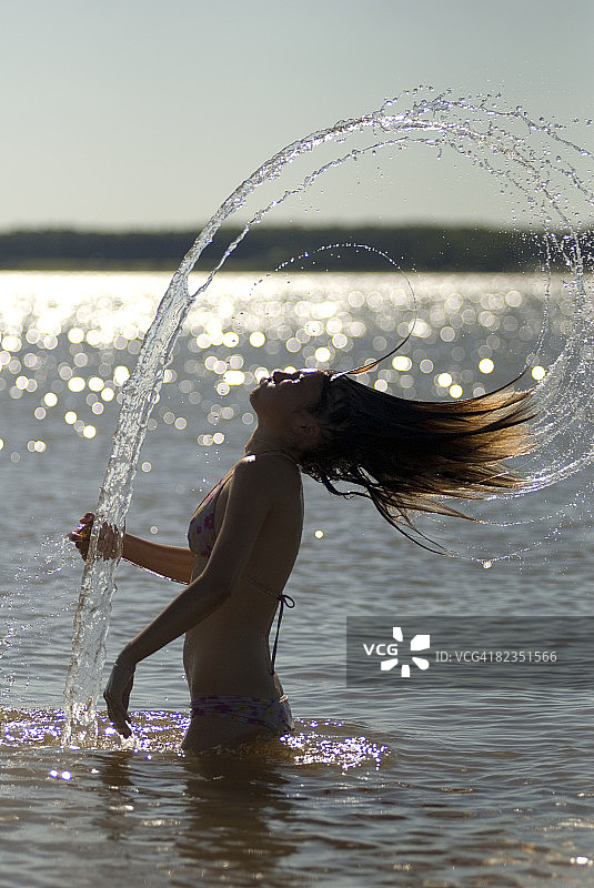 年轻女人侧脸：在乌拉圭萨尔托河边甩头发图片素材