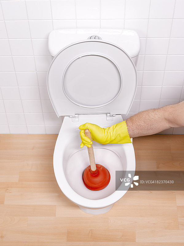 男人用马桶拔子疏通马桶图片素材