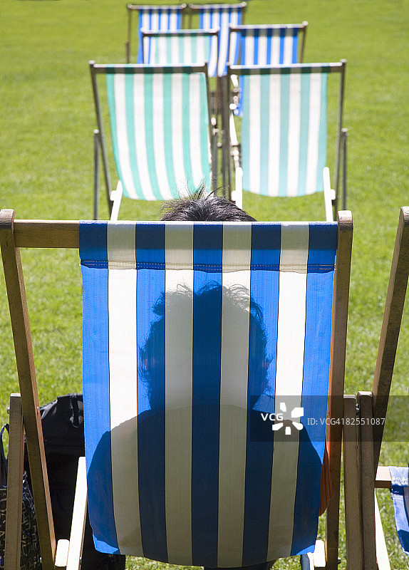 女人坐在公园的租赁躺椅上图片素材