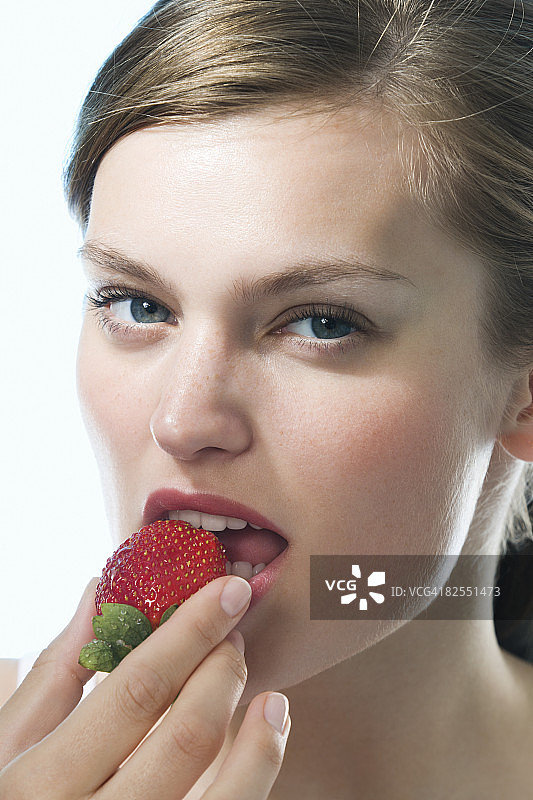 年轻女子吃草莓特写图片素材